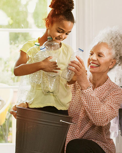 une femme et un enfant qui recyclent du plastique